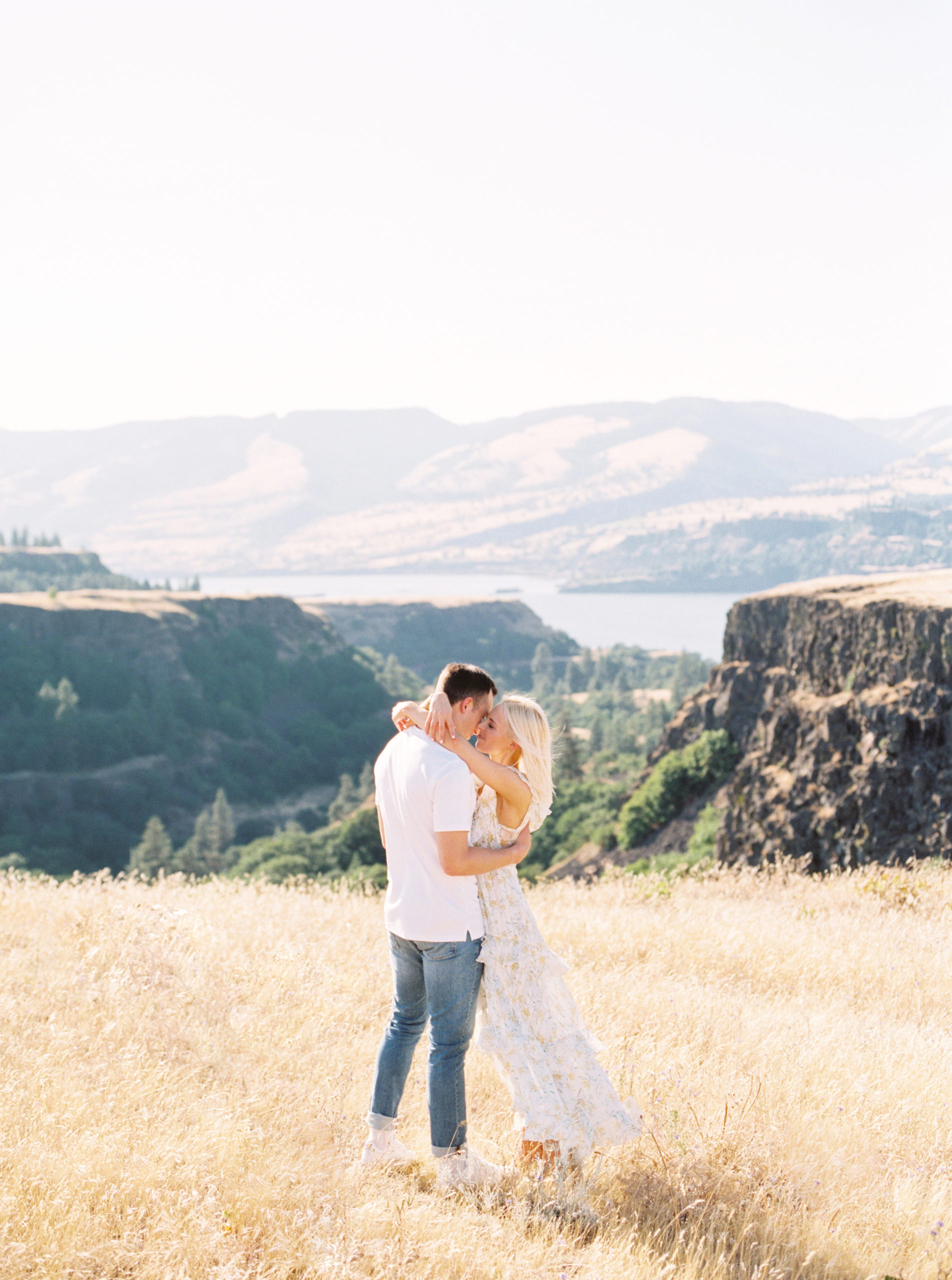 couple-standing-in-field-with-mountains-amandakphotography